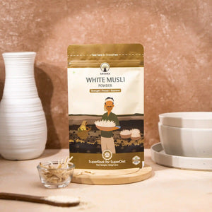 Arusha white musli powder pack displayed with dried musli roots on a wooden surface